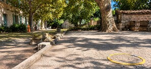 A courtyard with a gravel path, stone benches, and a hula hoop.