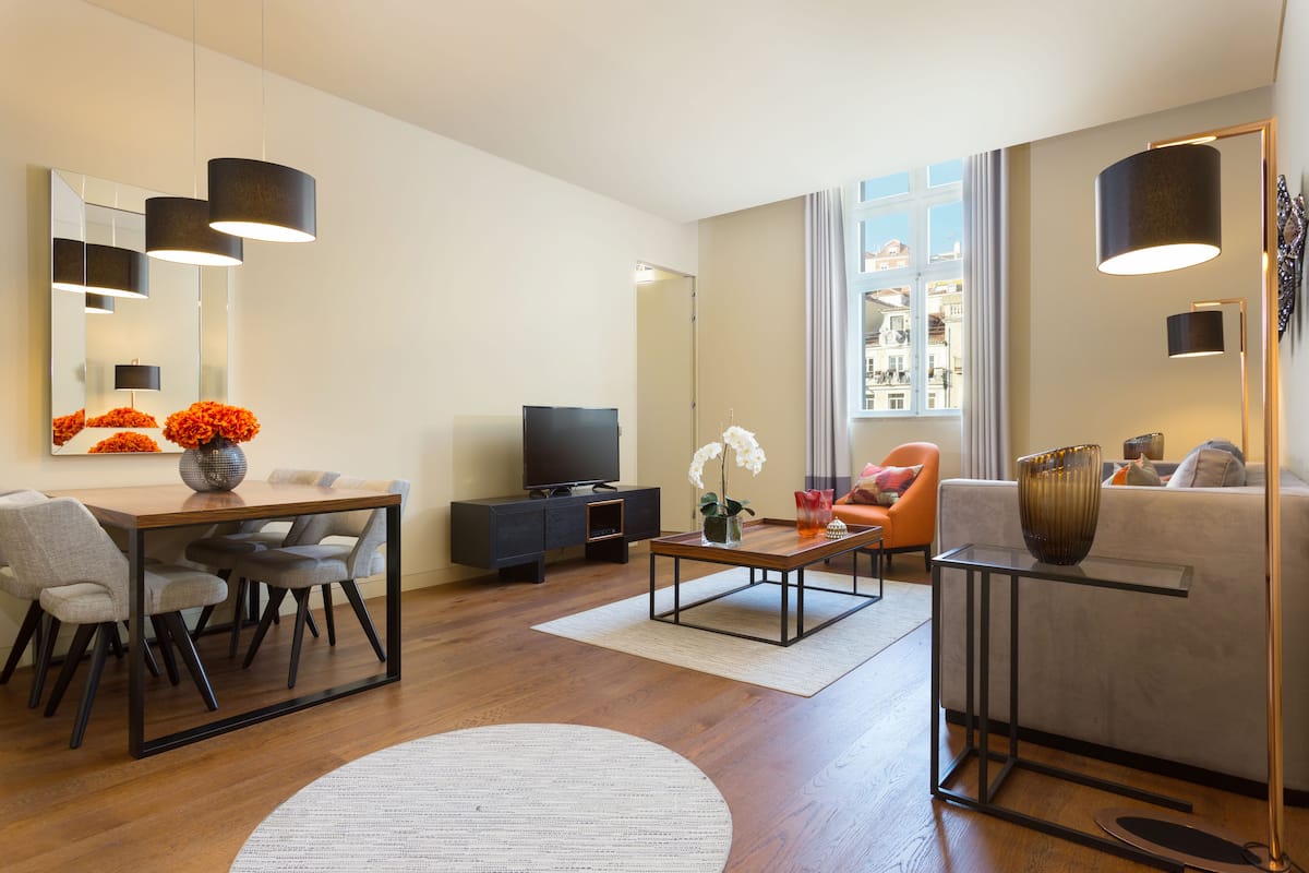 Ein modernes Wohnzimmer mit Essbereich, einer Couch und einem Fernseher.