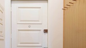 Una puerta blanca con una cerradura moderna y un pequeño dispositivo negro adherido.