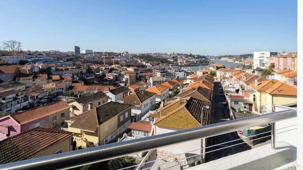 Un paisaje urbano con edificios residenciales y un rascacielos destacado a lo lejos.