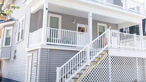 Una casa de dos pisos con un balcón y una escalera que sube al segundo piso.