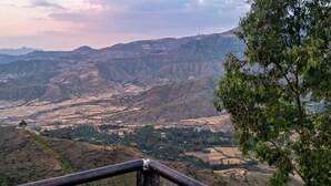 Un paisaje montañoso con un valle y una cadena montañosa distante.