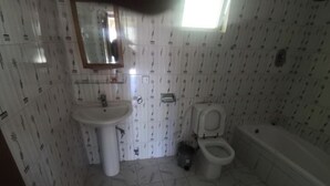 Un baño con lavamanos, inodoro y bañera.