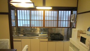 A compact kitchen with a sink, stove, and microwave.