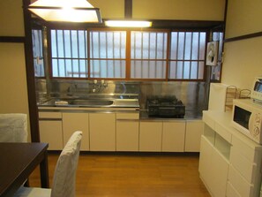 A compact kitchen with a sink, stove, and microwave.