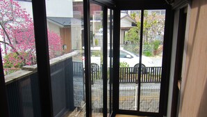 A corridor with wooden flooring leading to a glass door.