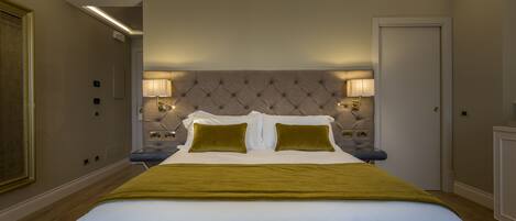 A neatly arranged hotel room with a large bed, two bedside lamps, and a framed picture on the wall.