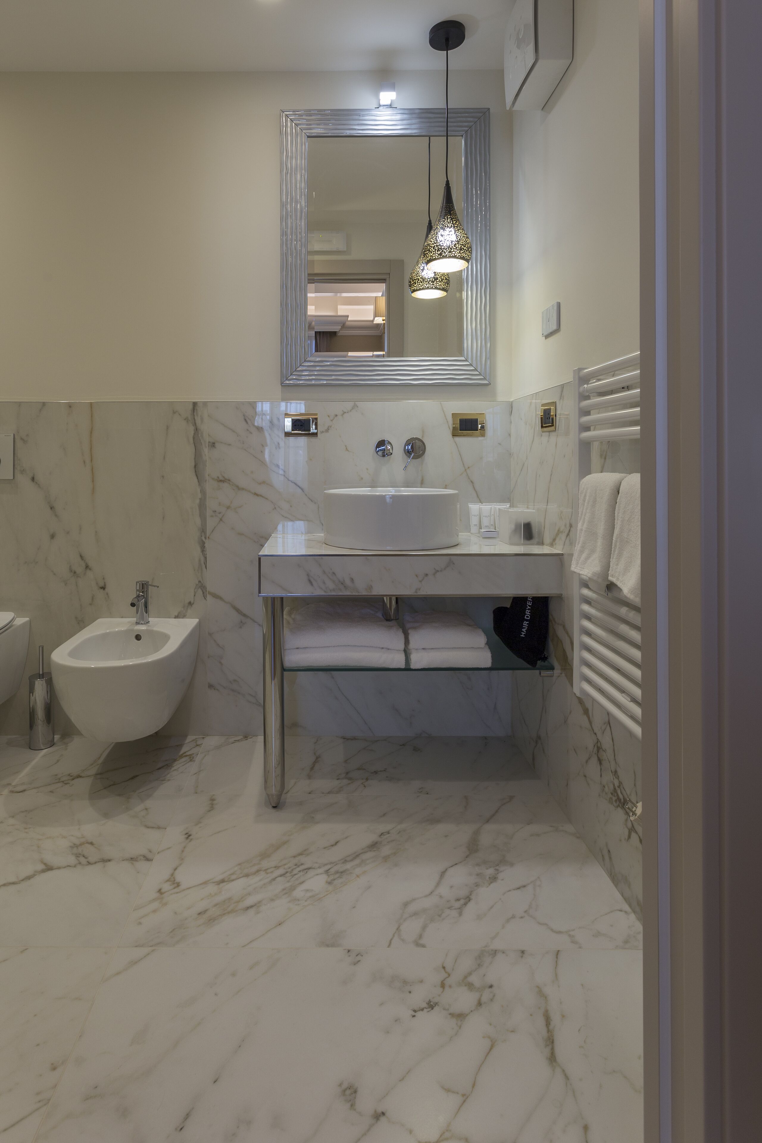Un bany modern amb bidet, un lavabo i un mirall.