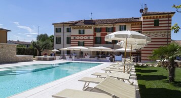 Una piscina al aire libre de temporada, sillones reclinables de piscina