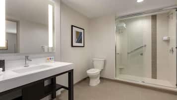 A modern bathroom with two sinks, a toilet, and a glass-enclosed shower.