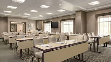 A conference room with multiple tables and chairs, equipped with nameplates and water glasses.