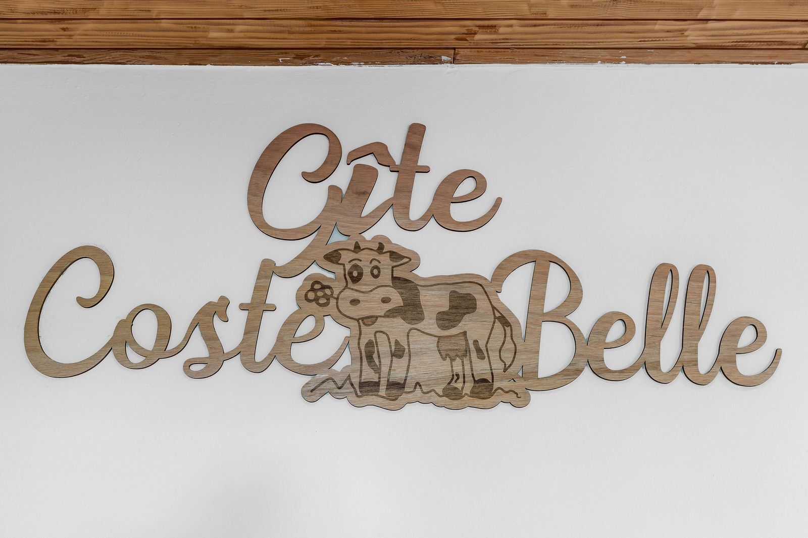 A wooden sign with the text "Corte Coste Belle" and a cow illustration.
