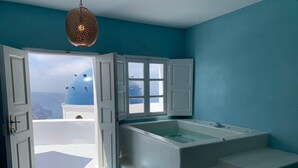 Une salle de bain avec une baignoire, une fenêtre et une vue sur la mer.
