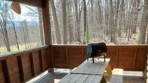 Une terrasse en bois avec une table de pique-nique et un barbecue.