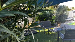 A patio area with a seating arrangement, a small table, and a statue. - Modern air-conditioned villa in a quiet location with swimming pool between Cassis and La Ciotat (Roquefort-la-Bédoule)