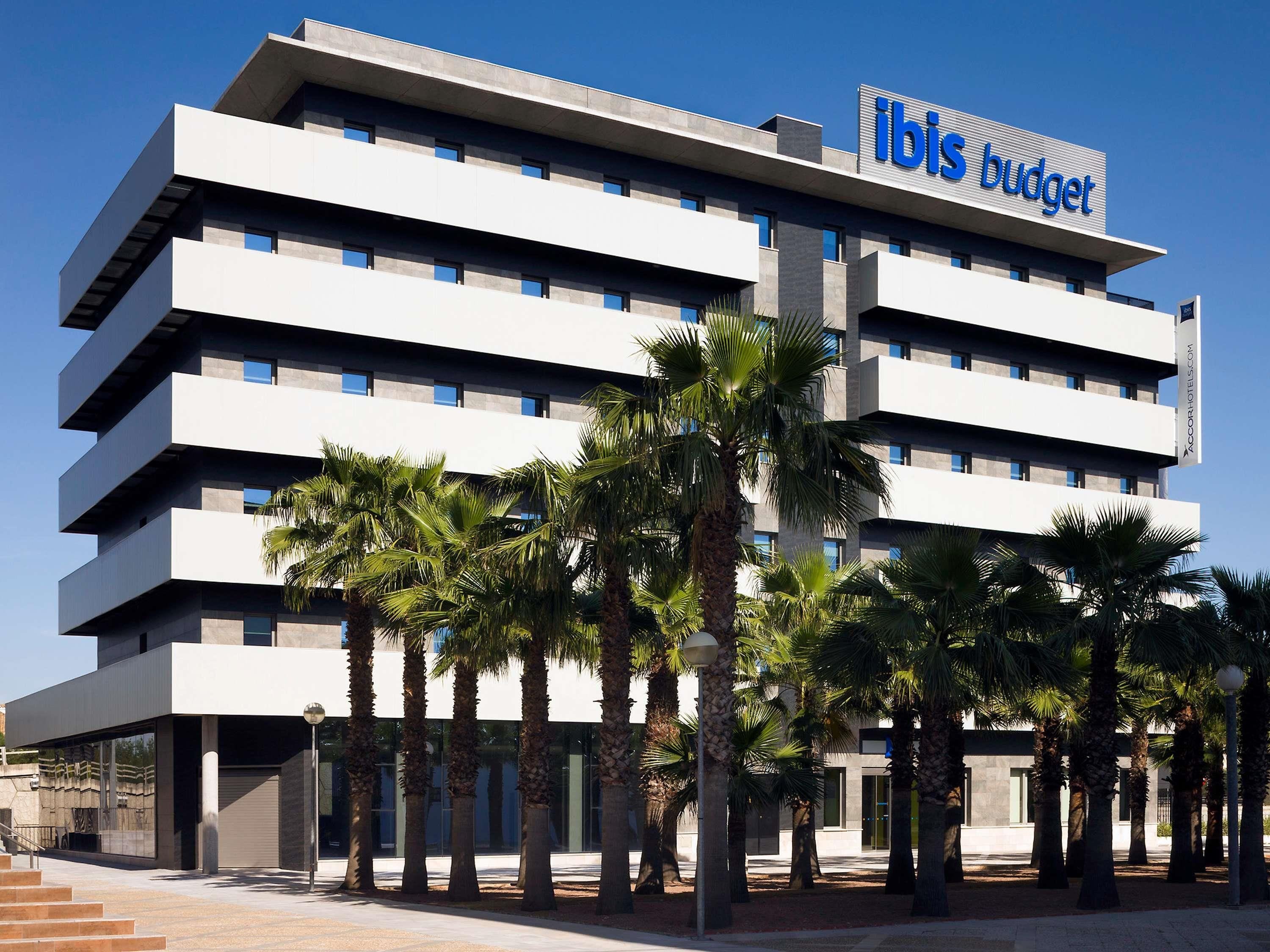 Ein mehrstöckiges Hotel mit flachem Dach und einem Schild mit der Aufschrift 'ibis budget'.