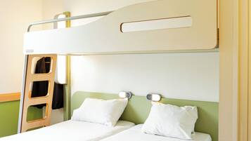 Una cama litera con escalera, dos almohadas y mesitas de noche.