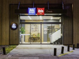 Fachada de un hotel con señalización de 'ibis budget' e 'ibis hotels Oviedo'.
