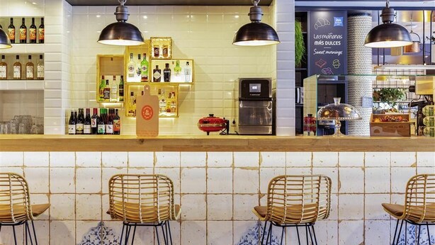 A bar area with tiled walls, hanging pendant lights, and bar stools. - ibis budget Oviedo (Oviedo)