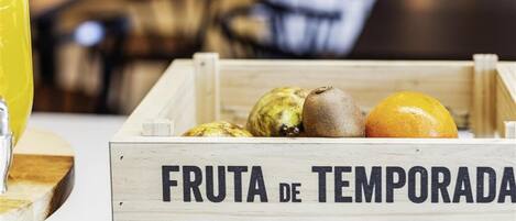 Una caja de madera etiquetada como “FRUTA DE TEMPORADA” con diversas frutas.