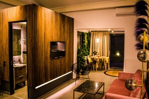 Relax in this stylish living room with a flat-screen TV, comfortable sofa, and elegant floor lamp.