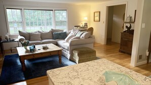 A living room with a sofa, coffee table, and a marble countertop. - Last Chance for August — A Bright, Breezy Stay on the Right Side of the Bridge (Harwich)