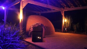 A brick oven under a wooden pergola at night. - Río Aventura Expediciones (Jalcomulco)