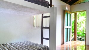 A room with a bunk bed, a window with a view of greenery, and a tiled floor. - Río Aventura Expediciones (Jalcomulco)