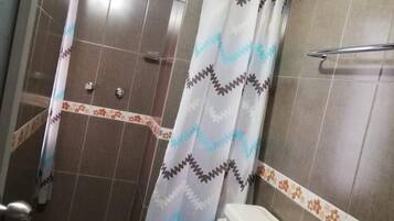 Un baño con ducha, inodoro y lavamanos.