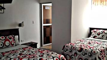Een hotelkamer met twee bedden, een televisie, een kledingkast en een schuifdeur naar een badkamer.