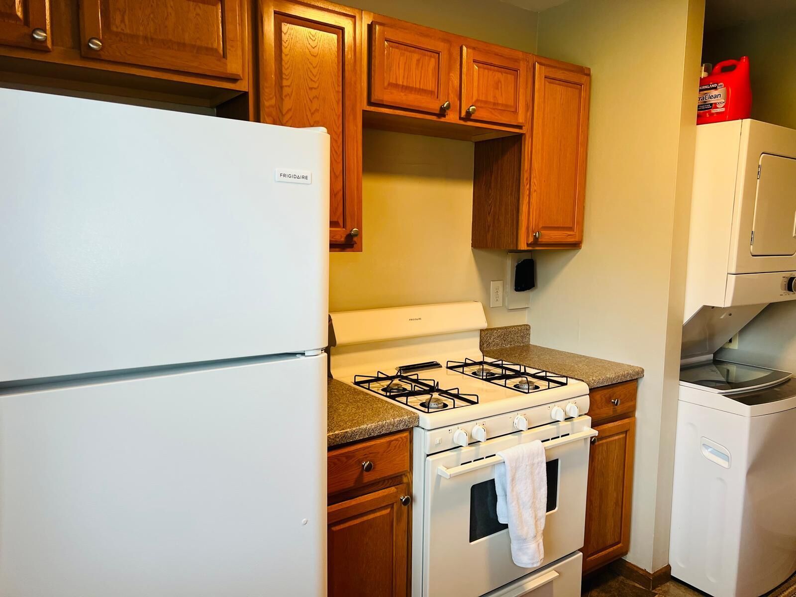 A kitchen with wooden cabinets, a white refrigerator, a gas stove, and a built-in oven.
