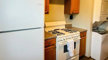 A kitchen with wooden cabinets, a white refrigerator, a gas stove, and a built-in oven.