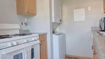 A kitchen with wooden cabinets, a white stove, and a refrigerator.