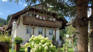 A traditional chalet with a balcony, surrounded by lush greenery and a well-maintained garden. - Holiday apartment Wambach (Kleines Wiesental)