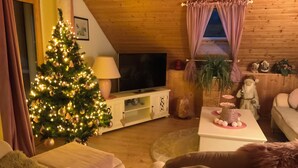 A cozy living room with a Christmas tree, a television, and a sofa. - Holiday apartment Wambach (Kleines Wiesental)