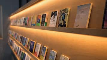 Uma parede com estantes cheias de livros, com títulos e imagens, dispostos em fila.