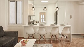 A modern kitchen with a central island, white cabinetry, and pendant lighting. - Kolonaki Square Executive Apartment (Athens)
