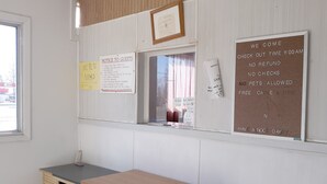 A room with a window, a desk, and various notices on the wall.