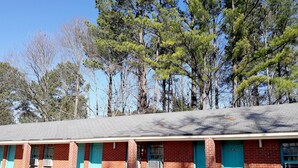 A motel with two rooms, each with a blue door and a window.