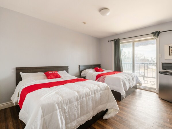 A hotel room with two beds, a large window with a view, and a small kitchenette. - Hotel Beaverton ON - Lake Simcoe (Brock)