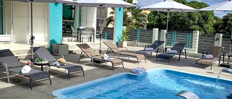 Piscina a l'aire lliure, para-sols i gandules