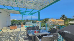 A balcony with a view of the sea, outdoor furniture, and a decorative ceiling. - Abiki Mauritius (Albion)