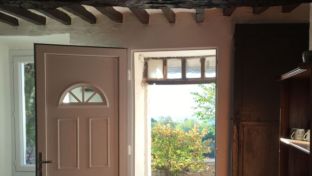 An open door leading to a stone-paved outdoor area with a view of greenery and a stone wall. - Stay in a 16th century three story home in the Provence countryside. (Mison)