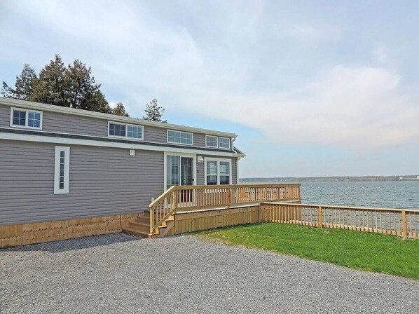 A two-story building with a wooden deck and a view of the water.