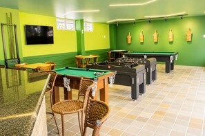 Eine Poolhalle mit mehreren Tischfußballtischen, Billardtischen und Sitzbereichen.