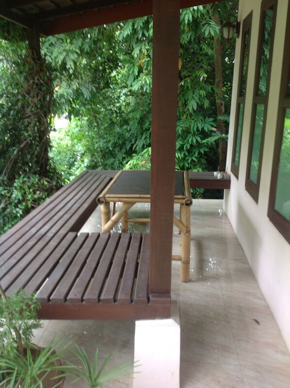 Relax in a serene garden setting with a shaded bench and table.