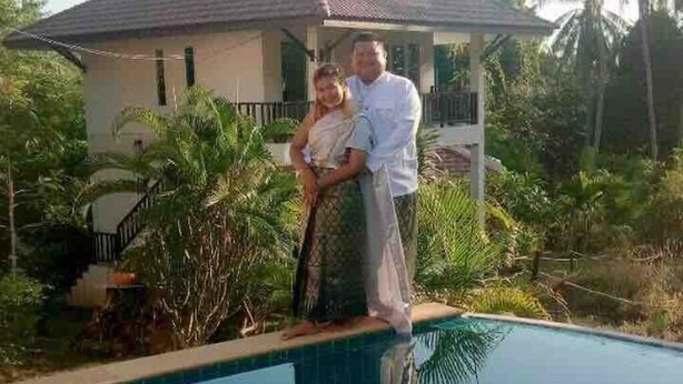 A swimming pool with a house in the background.