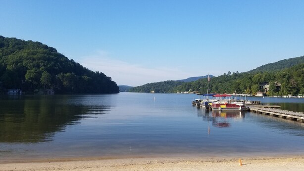 A calm lake with a dock and boats, surrounded by forested hills. - The Mountains Win Again (Lake Lure)