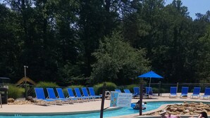 A swimming pool with clear blue water, surrounded by lounge chairs and a signboard. - The Mountains Win Again (Lake Lure)
