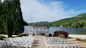 A gazebo with a view of a lake, surrounded by white chairs arranged for an event. - The Mountains Win Again (Lake Lure)